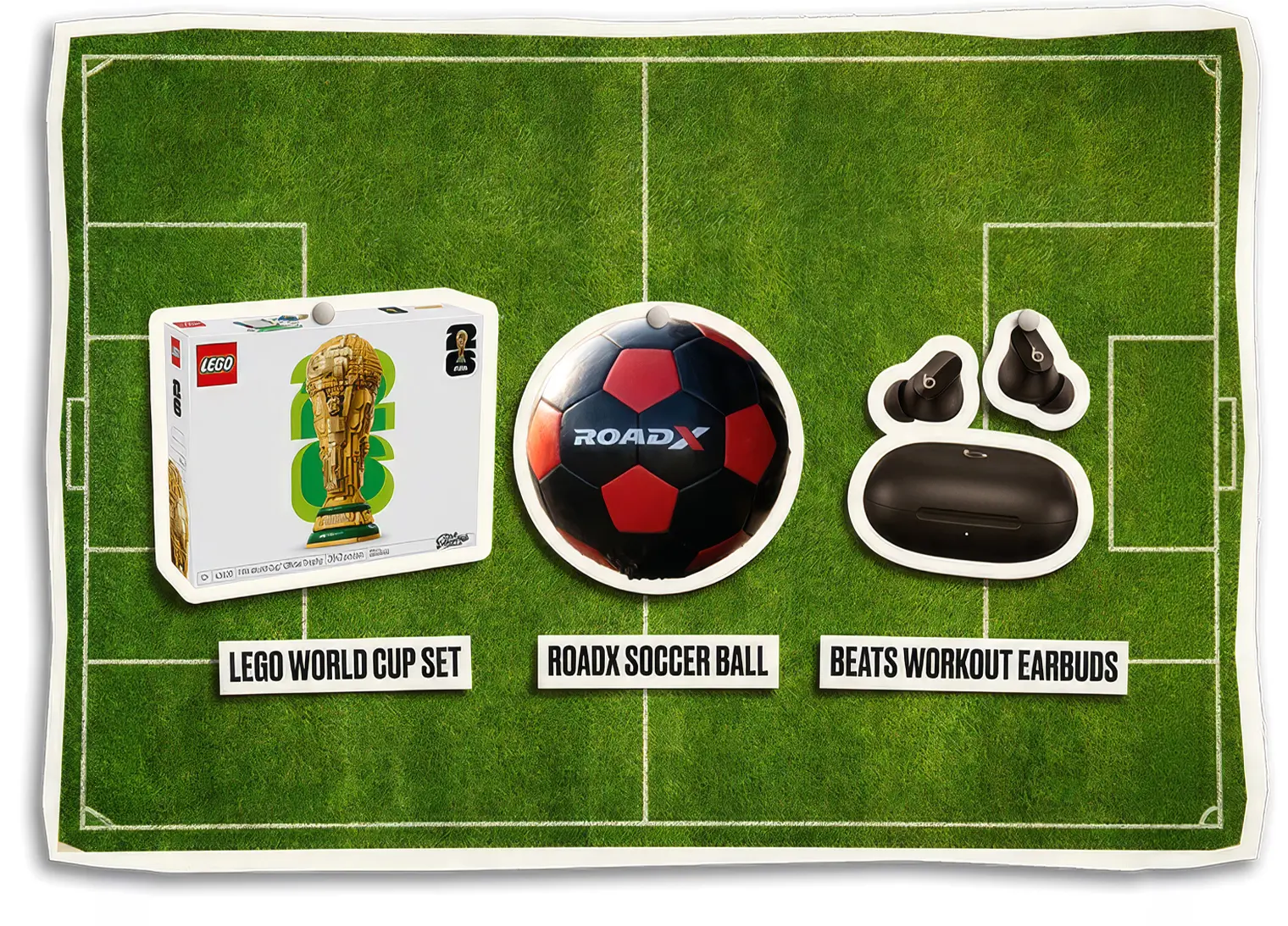 Soccer-themed prize board displayed on a green football pitch background featuring three rewards: a LEGO World Cup trophy building set, a RoadX-branded soccer ball, and a pair of Beats workout earbuds with charging case. The prizes are arranged across the field with labels beneath each item, resembling collectible game pieces placed on a soccer field.